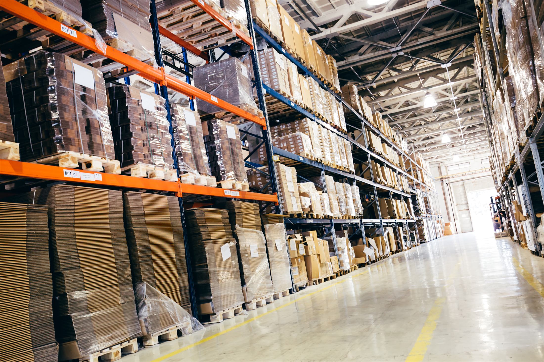 Almacén logístico con estanterías y palés de mercancía